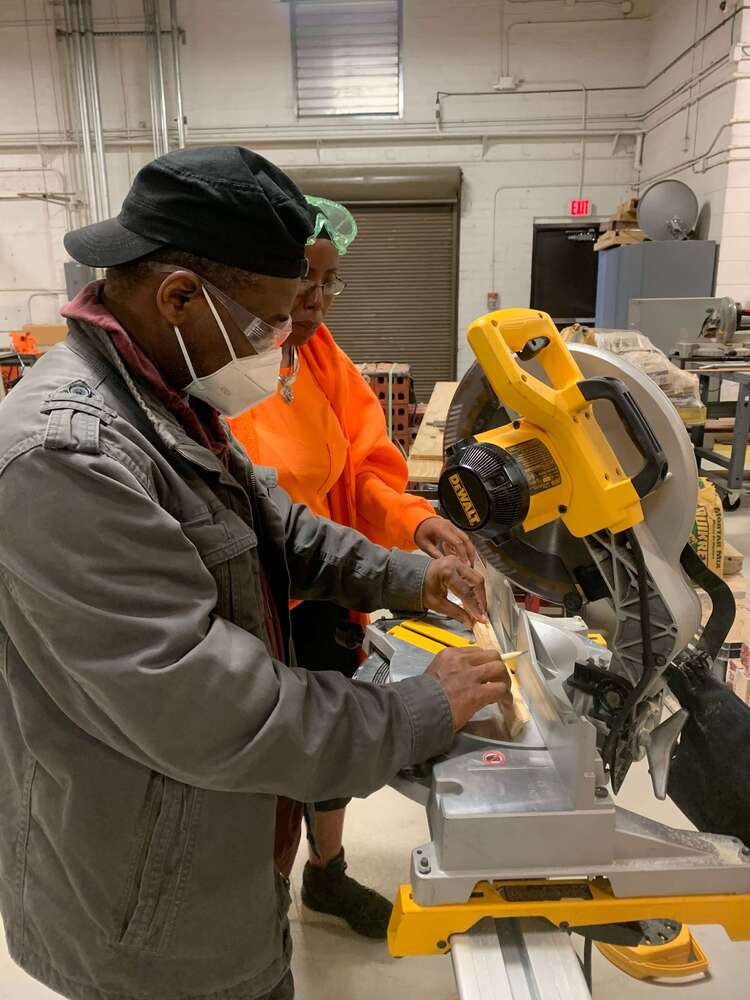 Residents using a saw to cut wood