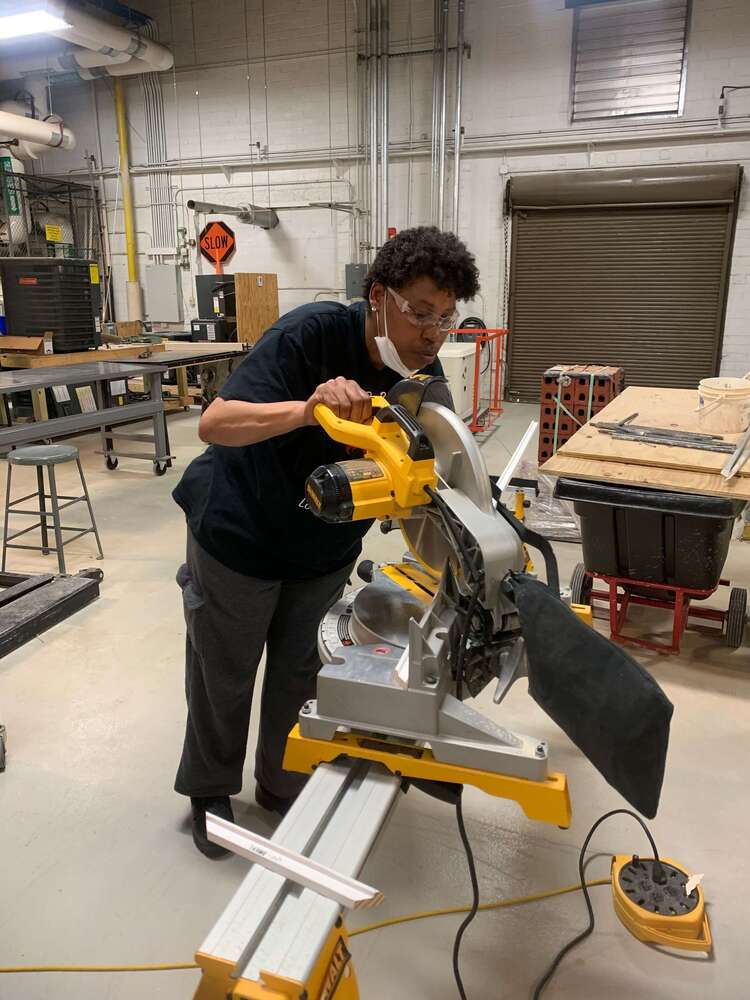 Student using a saw to cut wood