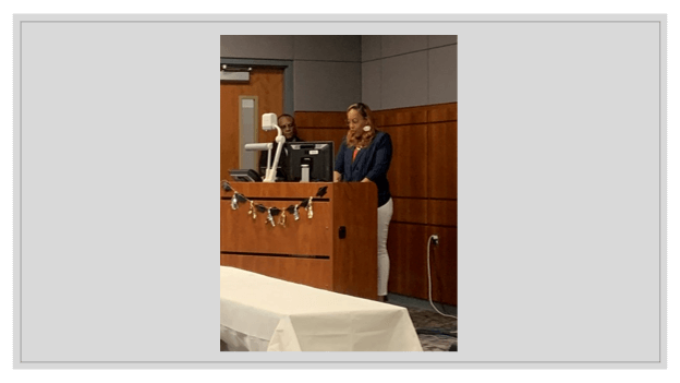 A woman speaking behind a podium