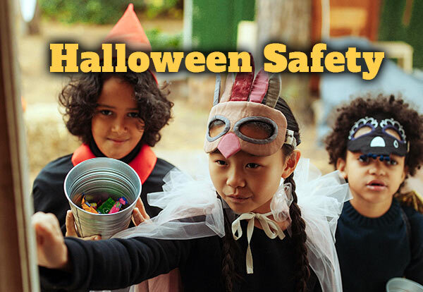 Halloween Safety Tips. Children in costumes trick or treating at a door.
