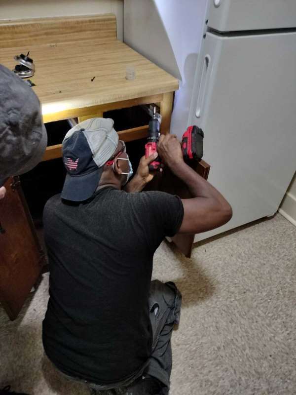 A. Soumah removing screws to remove the countertop