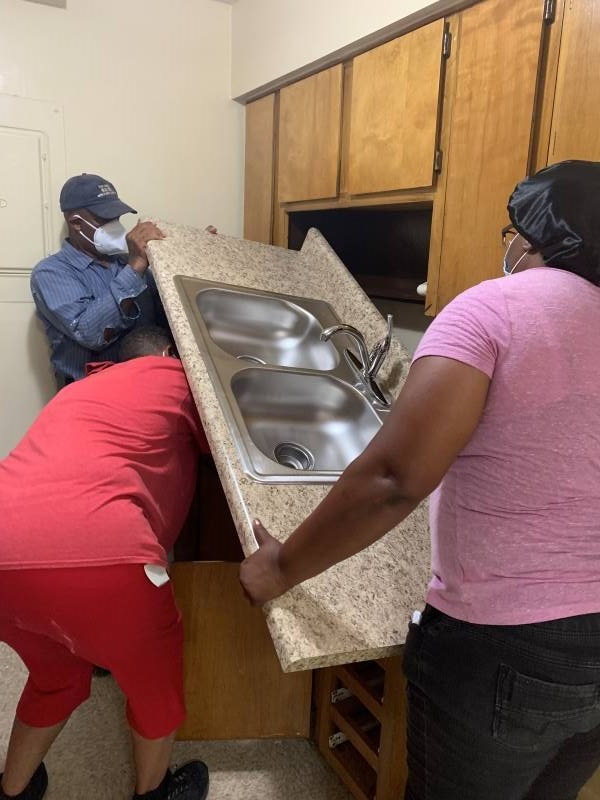 T. Hill and K. Williams removing a countertop.