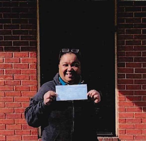 Tori Barnes holding a document and smiling.